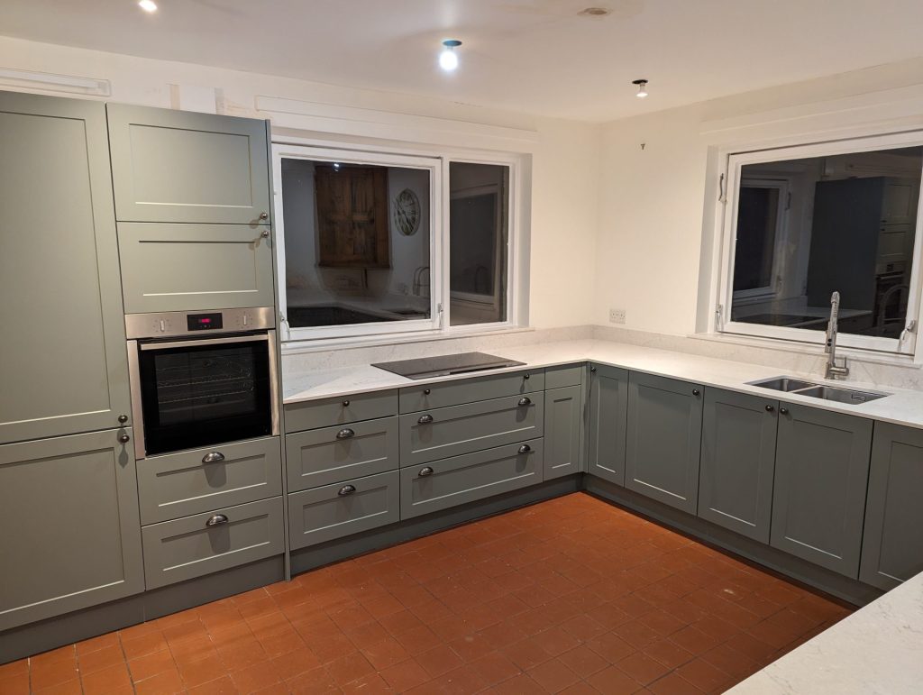 Spacious kitchen with grey cabinets and tiles